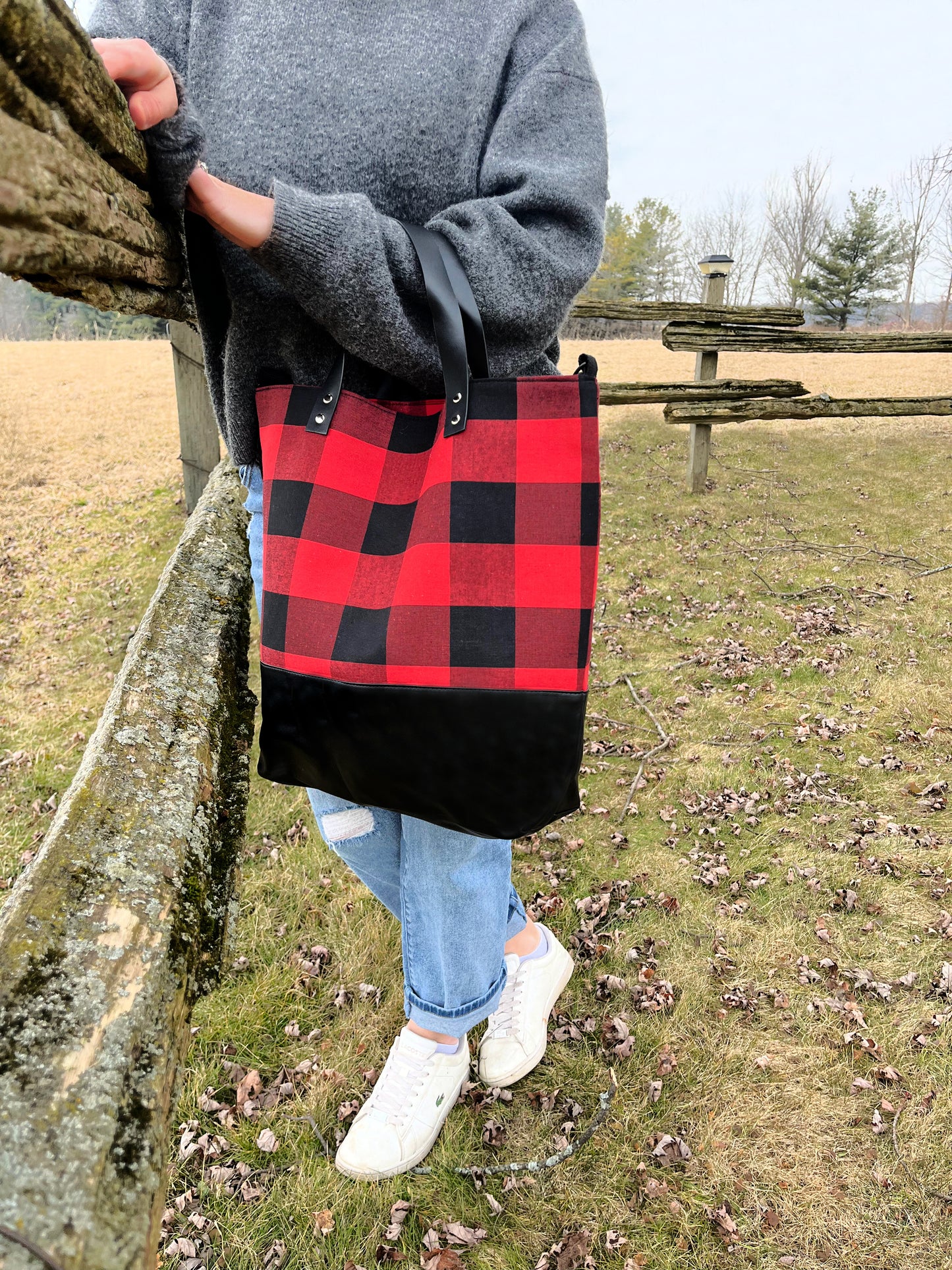 buffalo plaid tote with leather bottom on pictured in grass white sneakers grey top jeans