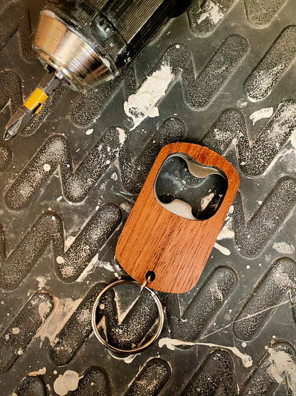 wood keychain bottle opener on work bench beside drill