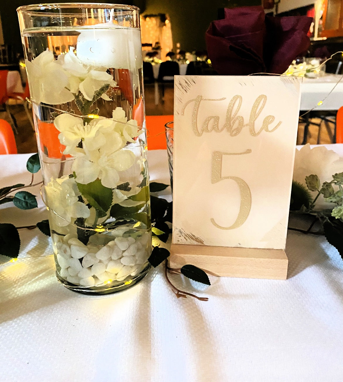 wedding table top sign with wood base and table number with vinyl by vase and candle 