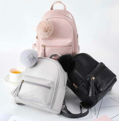 leather mini pack backs with hassle on zipper and Pom Pom white background , pink ,grey and black