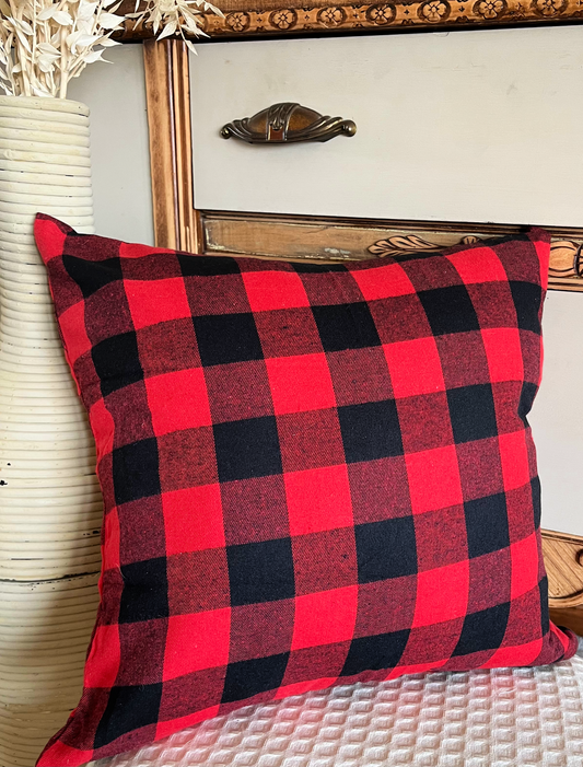 Buffalo plaid pillow leaning against vintage dresser