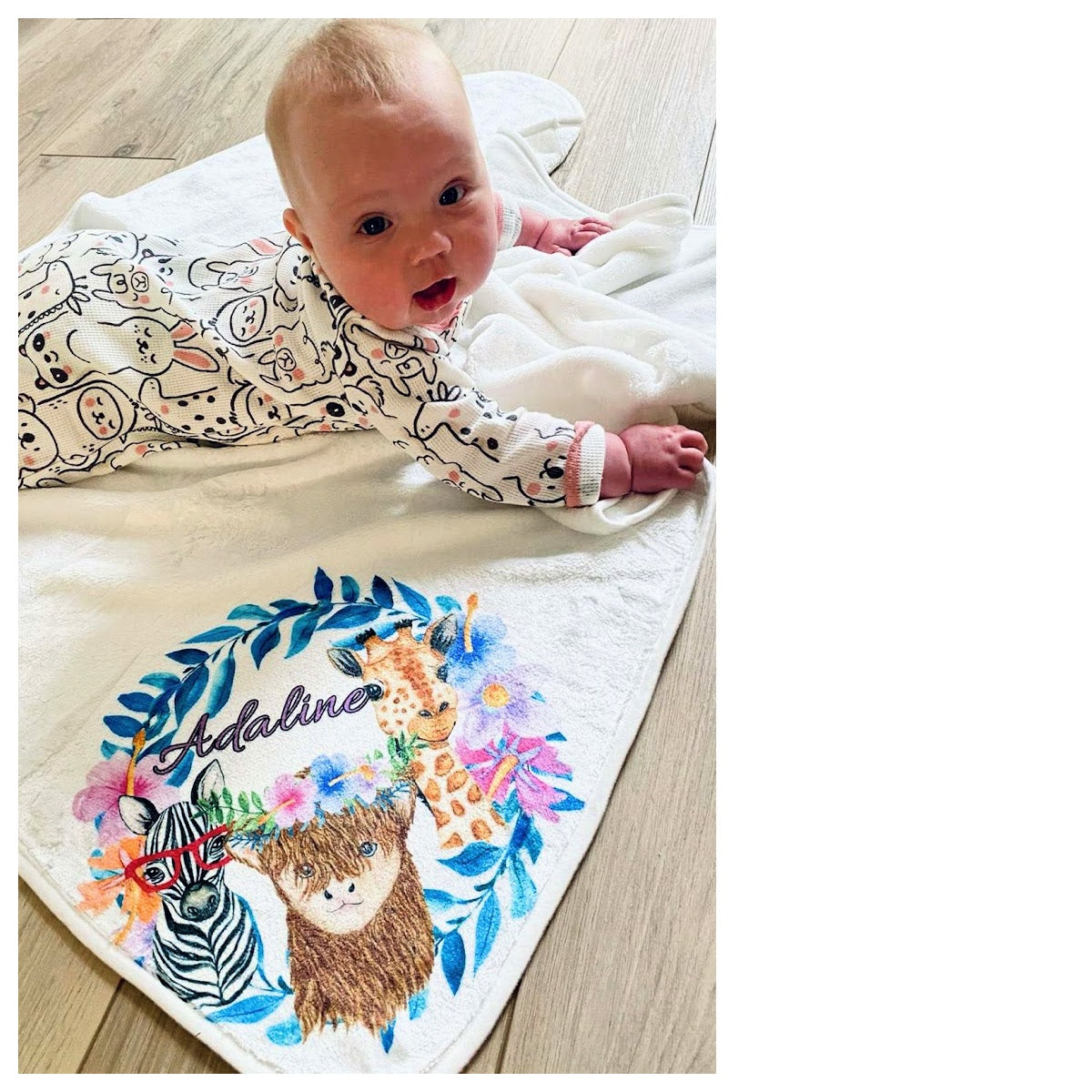 baby on personalized baby blanket with animals on floor