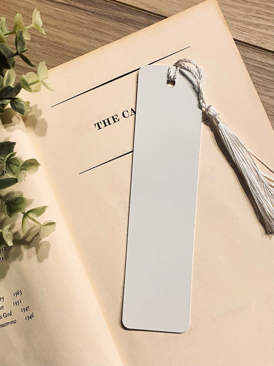 sublimation metal book mark with white tassel  slayed on book with wood background 