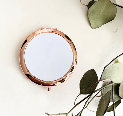 rose gold compact mirror with white sublimation piece on white background with leaves