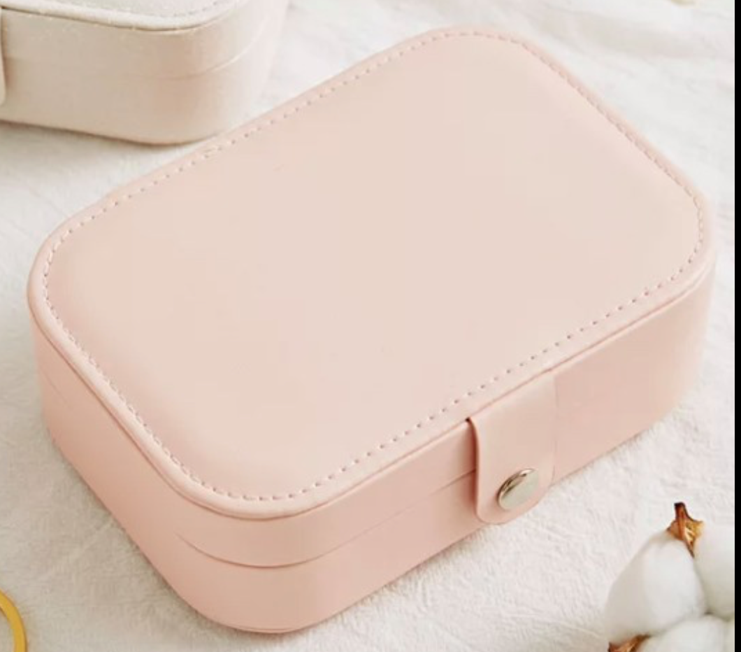 square pink jewellery case on white background snap closure 