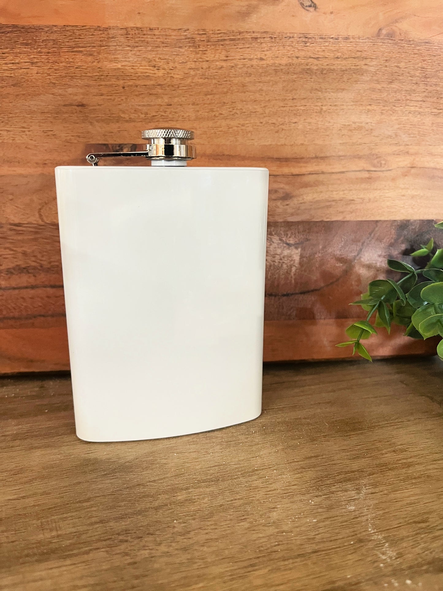 8oz sublimation white stainless steel flask infront of a wood background with green leaves