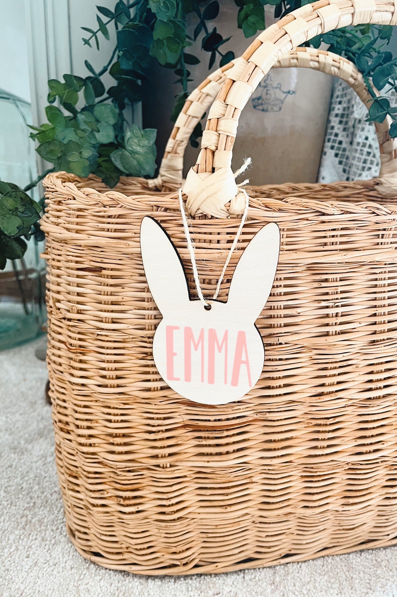 wooden bunny tag on brown basket with greenery in the background