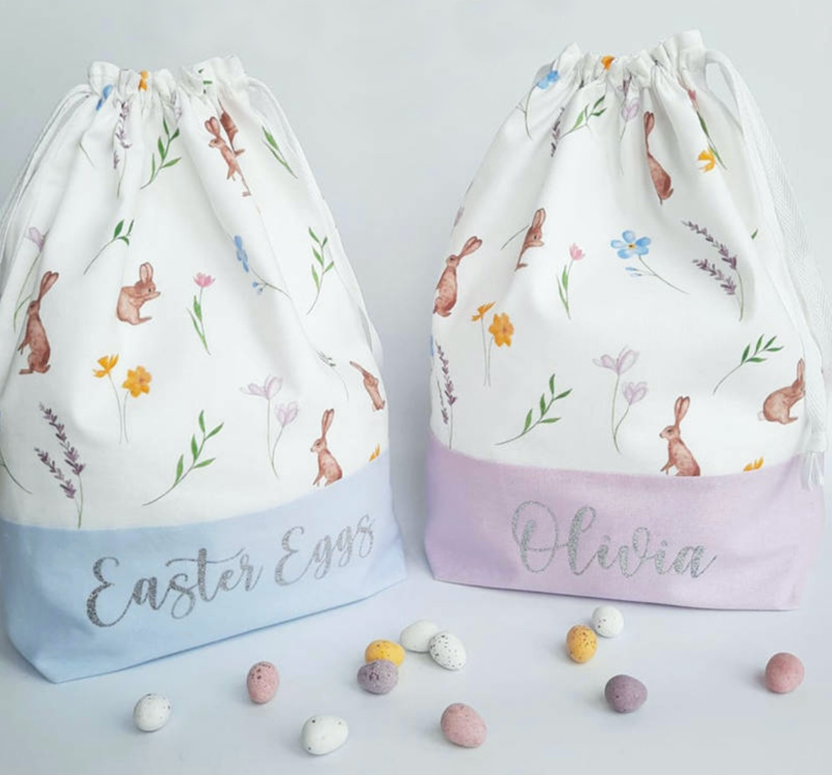 Blue and Lilac Easter drawstring bunny bag with rabbits flowers and leaves on white background with candy eggs