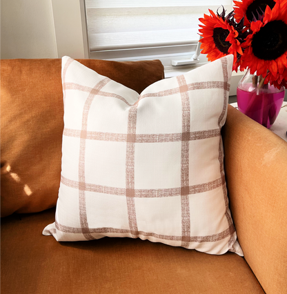 accent pillow with brown checkered battern on orange accent chair and red sunflowers 