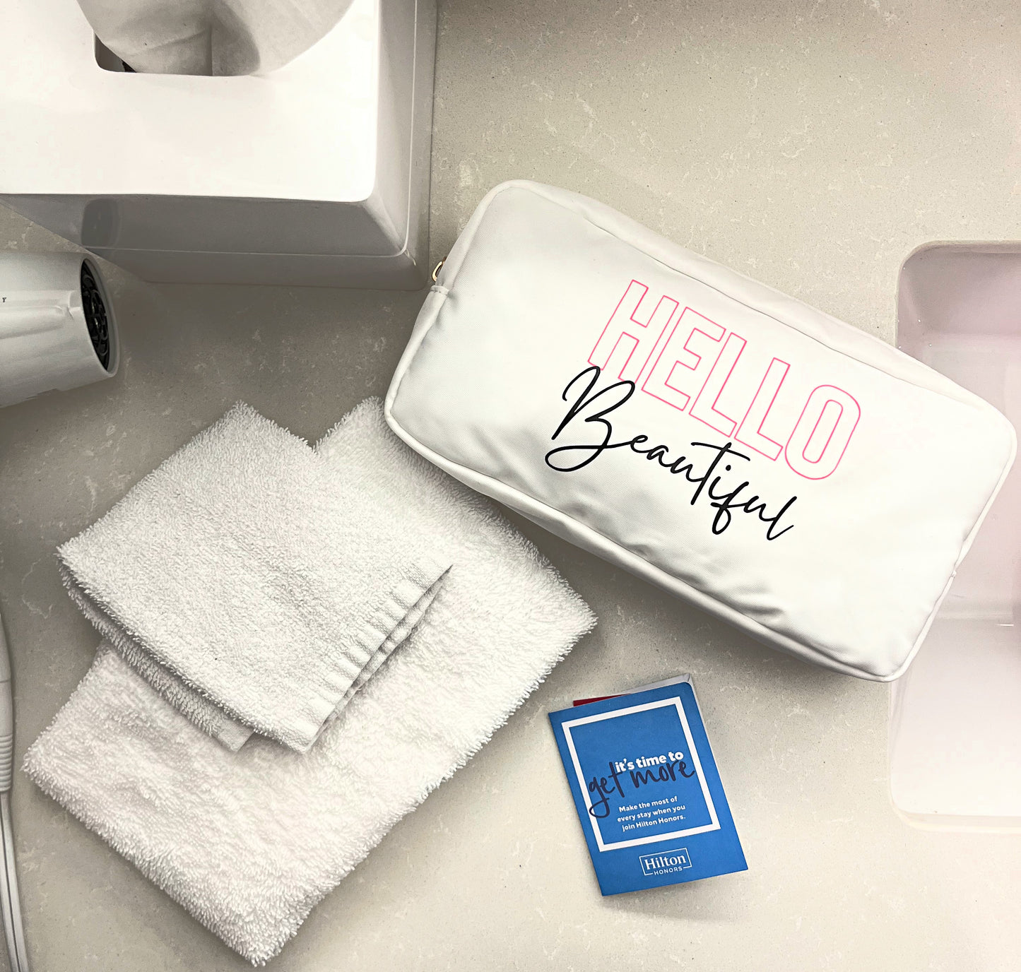 white makeup pouch personalized with HTV hello beautiful on hotel vanity 