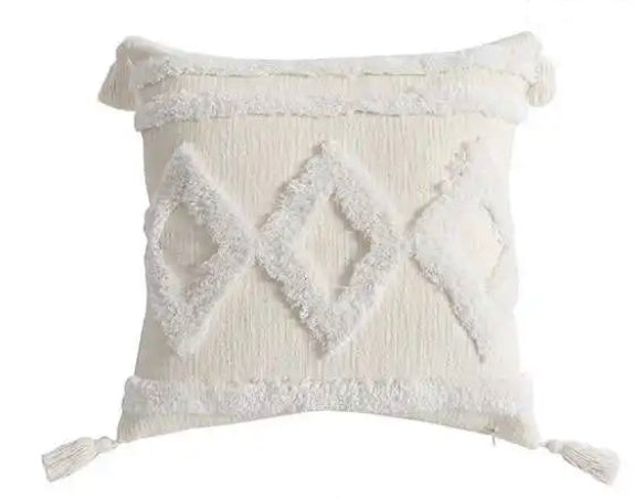 accent pillow with tassels and fuzzy raised triangle pattern on white background