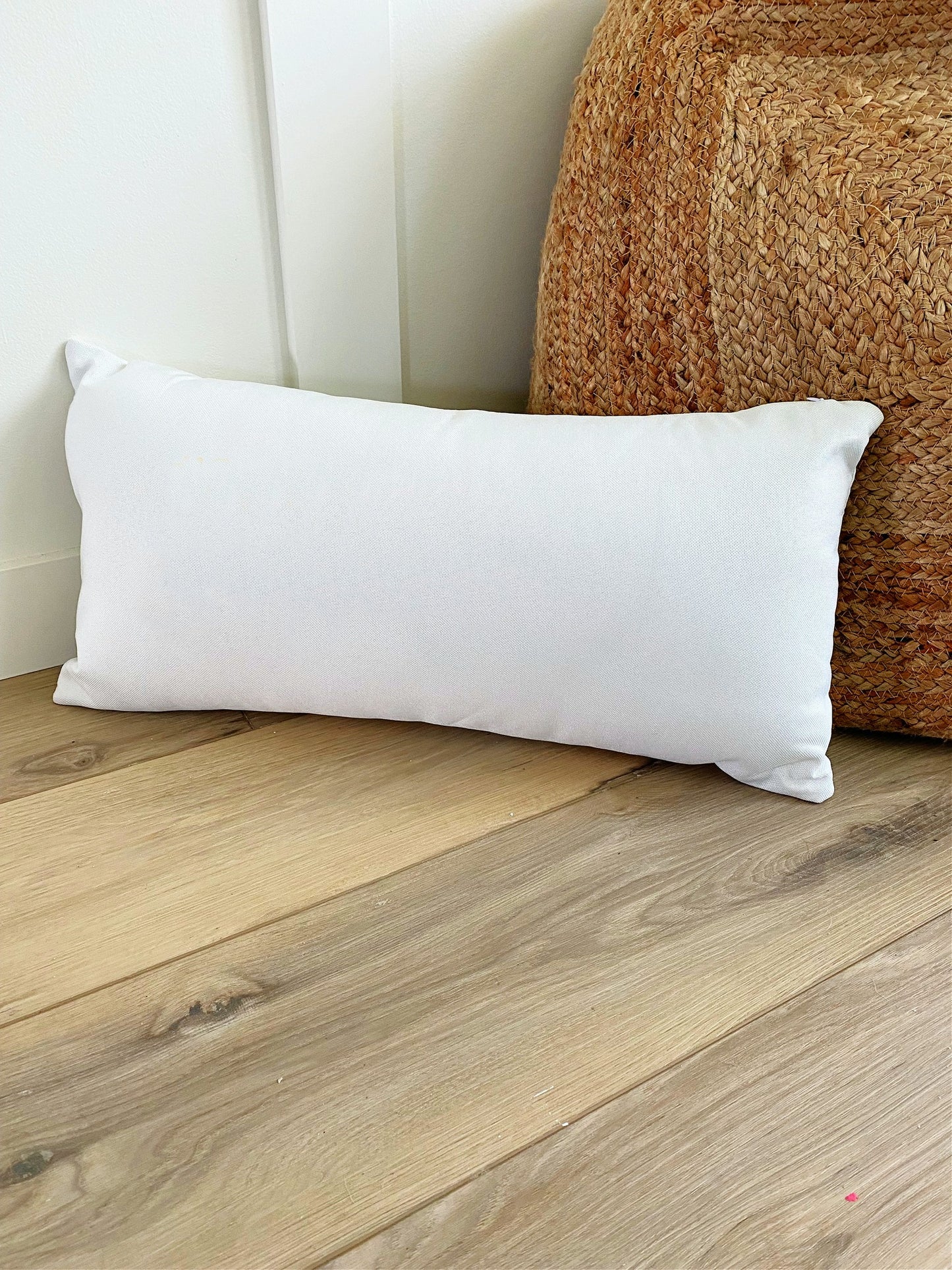 blank white lumbar pillow for sublimation or htv on wood floor infront of wicker poof